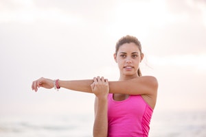 Photo of woman in pink stretching her arms